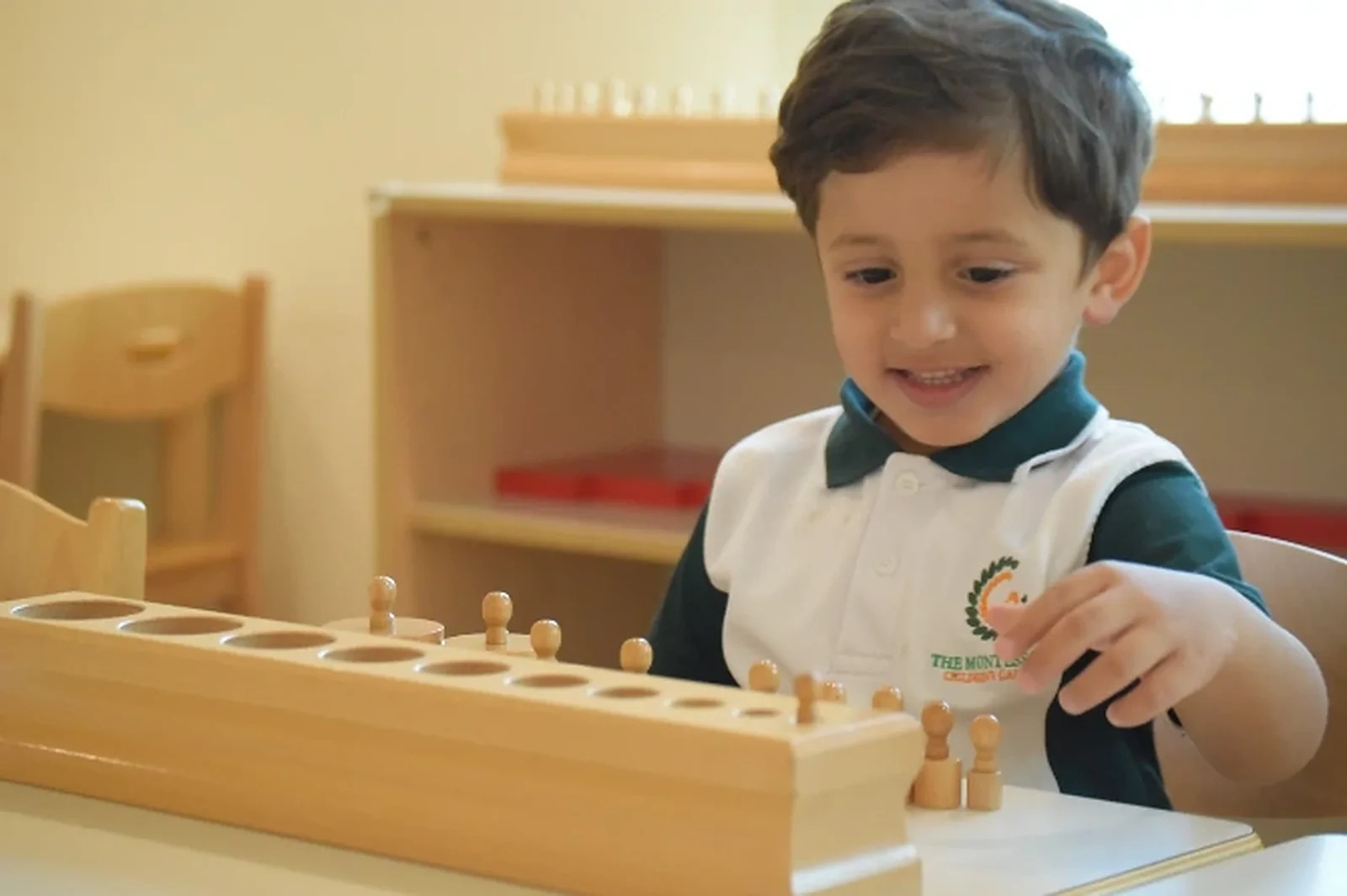 A TMCG child concentrating on an independent Montessori activity